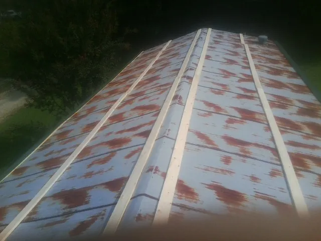 Rusted metal roof panels with new wood purlins before replacement — Storm Damage Roof Repair in Ayden by Roofing Brothers